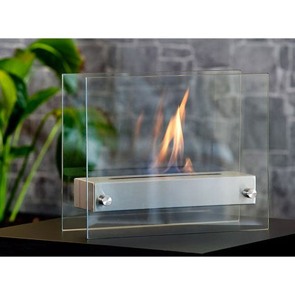 bioethanol-tischkamin-ethanol-tischfeuer-oxy-edelstahl-mit-glas-mit-flammen-auf-schwarzen-tisch-vor-einer-pflanze-und-steinwand